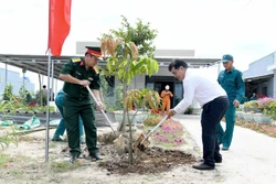 西宁省人民委员会代主席阮鸿成（右）在周城县和会乡波楞村常驻民兵哨所植树。图自越通社