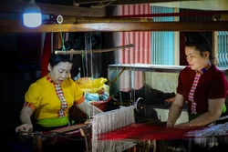 傣族妇女每日在织布机旁专注编织色彩斑斓的土锦布。图自越通社