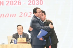 越南政府总理范明政对洪水和山体滑坡灾害中营救奠边省车容乡杭普喜村90 名村民的村长莫阿诗予以鼓励表扬。图自越通社