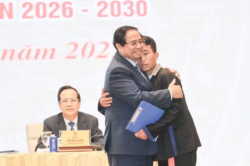 越南政府总理范明政对洪水和山体滑坡灾害中营救奠边省车容乡杭普喜村90 名村民的村长莫阿诗予以鼓励表扬。图自越通社