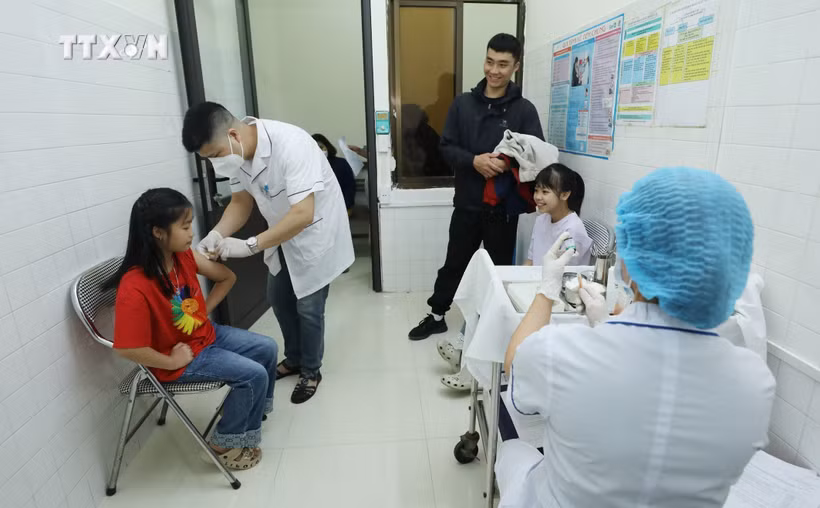 附图：谅山省医护人员为儿童接种麻疹疫苗。图自越通社