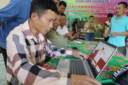 在莱州省芒模乡葬俄村，支部书记李文占指导党员设置电子党员手册。