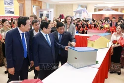 越南政府总理范明政参观各地方住房设计模式。 