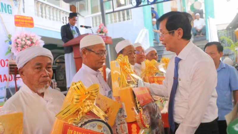 安江省人民委员会副主席黎文福（右）在迎接斋月仪式之际，向安江省伊斯兰清真寺和小清真寺管理委员会代表赠送礼物。