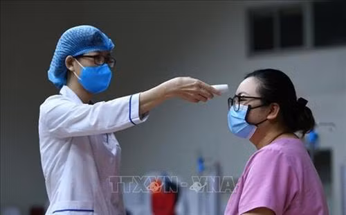 医务人员进行体温测量。图自越通社 医务人员进行体温测量。图自越通社