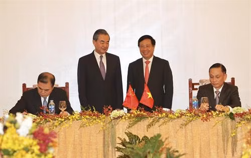 越南政府副总理兼外长范平明和中国外长王毅出席签署仪式。（图片来源：越通社）