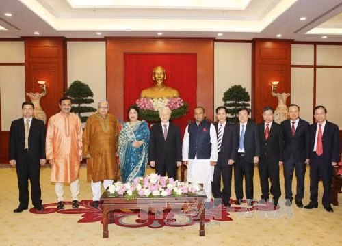 越共中央总书记阮富仲与孟加拉国国民议会议长希琳•沙尔敏•乔杜里同两国代表合影。（图片来源：越通社）