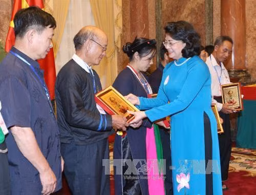 国家副主席邓氏玉盛向少数民族先进模范代表人士赠送礼物。越通社记者 伊晋 摄 国家副主席邓氏玉盛向少数民族先进模范代表人士赠送礼物。越通社记者 伊晋 摄