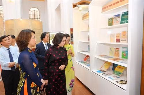 代表们参观此展上的资料。图自越通社