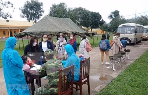 越南职能机关对从外国回来并正在接受集中隔离的公民进行体温测量。图自越通社