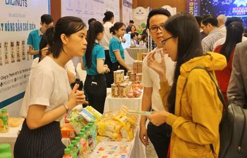 农业企业代表向参观者介绍产品。图自越通社 农业企业代表向参观者介绍产品。图自越通社