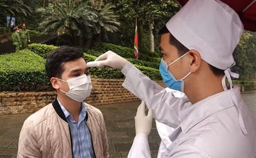 入庙上香的游客们必须佩戴口罩,接受体温测量。图自越通社 入庙上香的游客们必须佩戴口罩,接受体温测量。图自越通社
