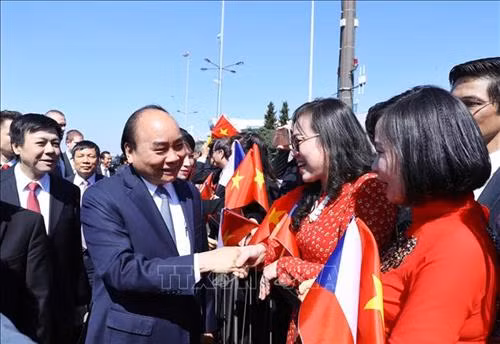 众多旅捷越南人到机场迎接阮春福一行。图自越通社