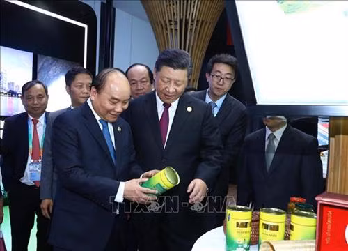 越南政府总理阮春福与中国国家主席习近平参观越南展位。图自越通社