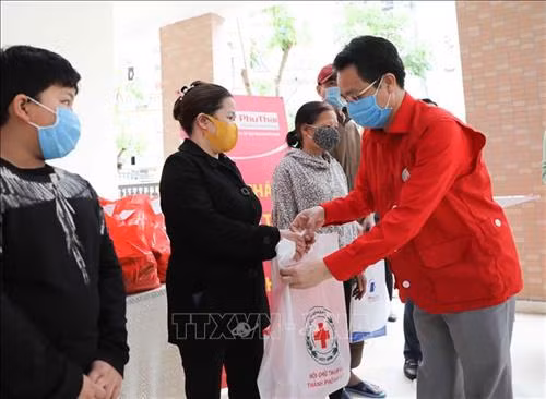 河内市红十字会主席向受疫情影响的贫困群众。图自越通社 河内市红十字会主席向受疫情影响的贫困群众。图自越通社