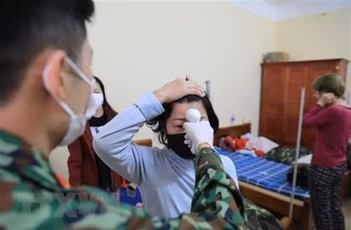 部队战士对隔离人员进行体温检测 图自越通社 部队战士对隔离人员进行体温检测 图自越通社