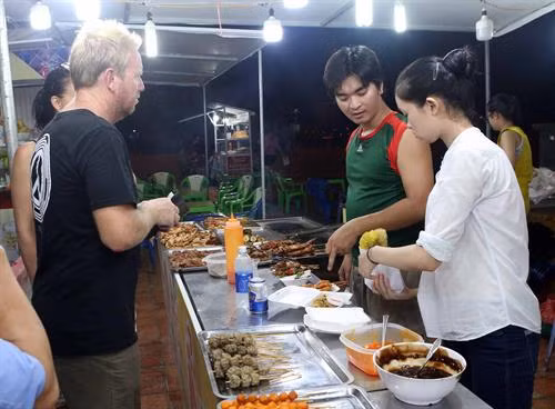 国际游客品尝岘港的美食。(图片来源:越通社) 国际游客品尝岘港的美食。(图片来源:越通社)