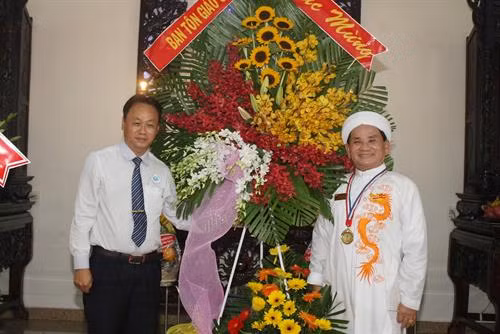 政府宗教委员会领导向越南高台教管理委员会会长阮友仁赠送鲜花。图自越通社 政府宗教委员会领导向越南高台教管理委员会会长阮友仁赠送鲜花。图自越通社
