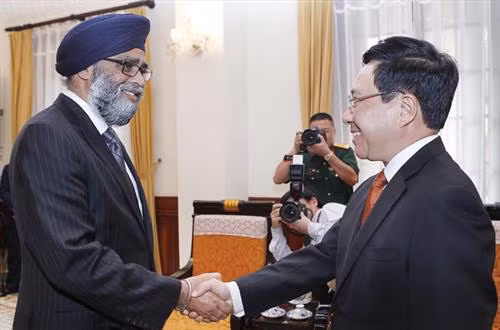 越南政府副总理兼外交部长范平明会见加拿大国防部长Harjit Singh Sahan。（图片来源：越通社）