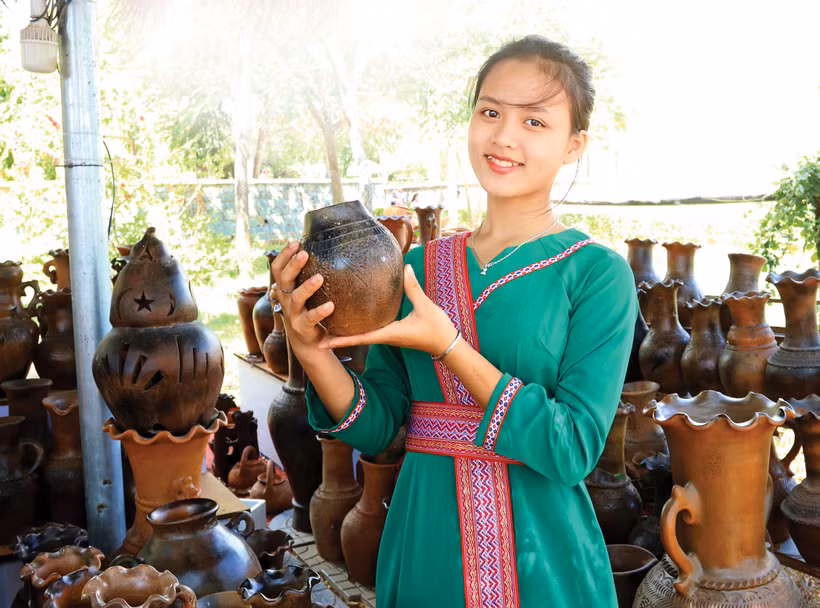 占族少女在潘朗 - 塔占市某处旅游景点介绍宝竹陶瓷产品