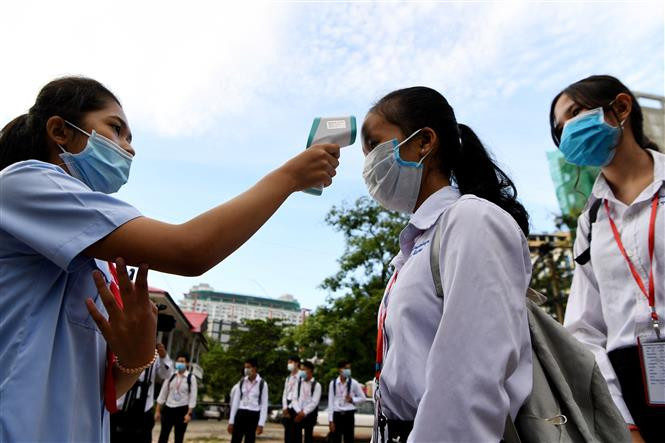 柬埔寨学校检查学生的体温。图自越通社/AFP 新冠肺炎疫情:东南亚各国加大疫情防控力度 ảnh 1
