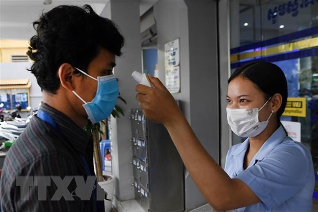 资料图:医务人员对客户进行体温测量。图自越通社 越南外交部发言人:感染新冠病毒的13名在柬越南人健康状况稳定 ảnh 1