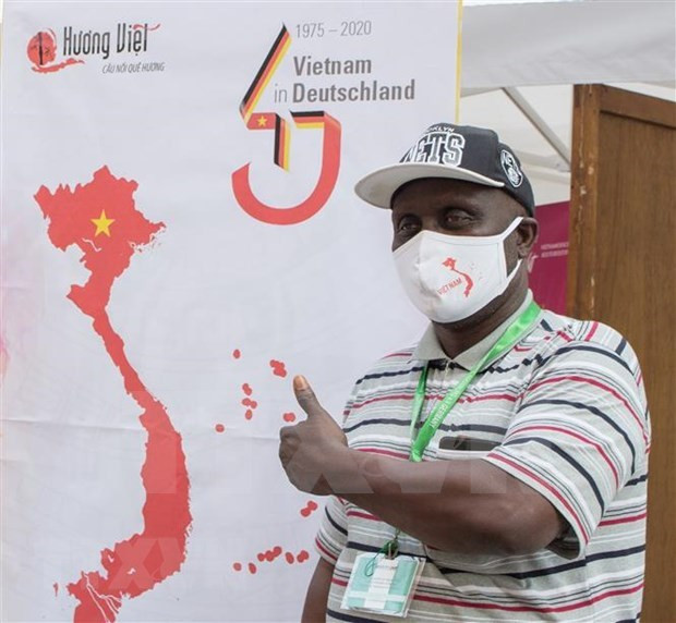 参观越南展位的每一位参观者都获得上面印有包括黄沙和长沙两个群岛的越南地图的1只口罩。图自越通社 越南在德国南部推介越南风土人情 ảnh 2