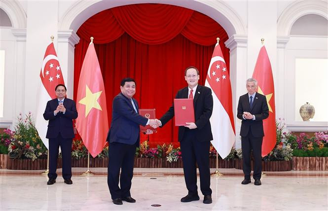 两国合作文件的签署仪式。图自越通社 越南政府总理范明政与新加坡总理李显龙举行会谈 ảnh 3