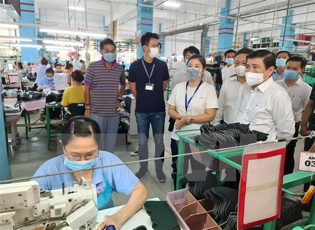 胡志明市人民委员会主席阮成峰视察当地企业运营情况。图自越通社 胡志明市坚持与受疫情影响企业共同度过难关 ảnh 1