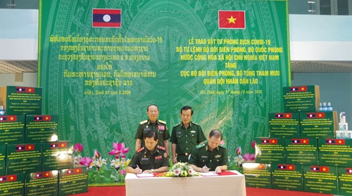 双方代表签署医疗物资交接记录。图自人民军队报 越南与老挝加强边境管控工作中的配合 ảnh 2