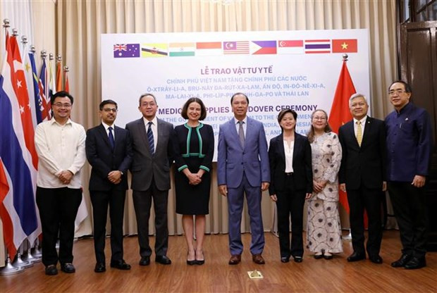 越南外交部副部长阮国勇与各代表合影 图自越通社 越南象征性地将防疫物资移交给8个国家 ảnh 1