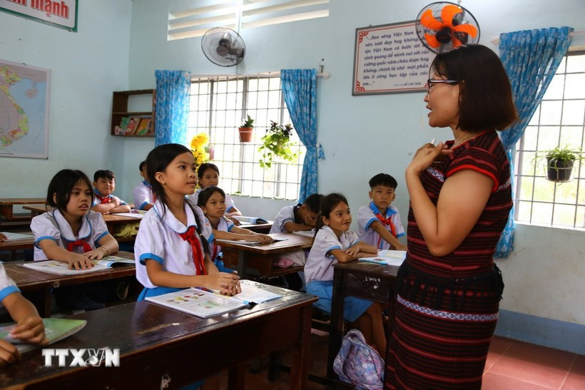 阮红女老师引导同奈省春城乡阮劝小学学生学英语发音。