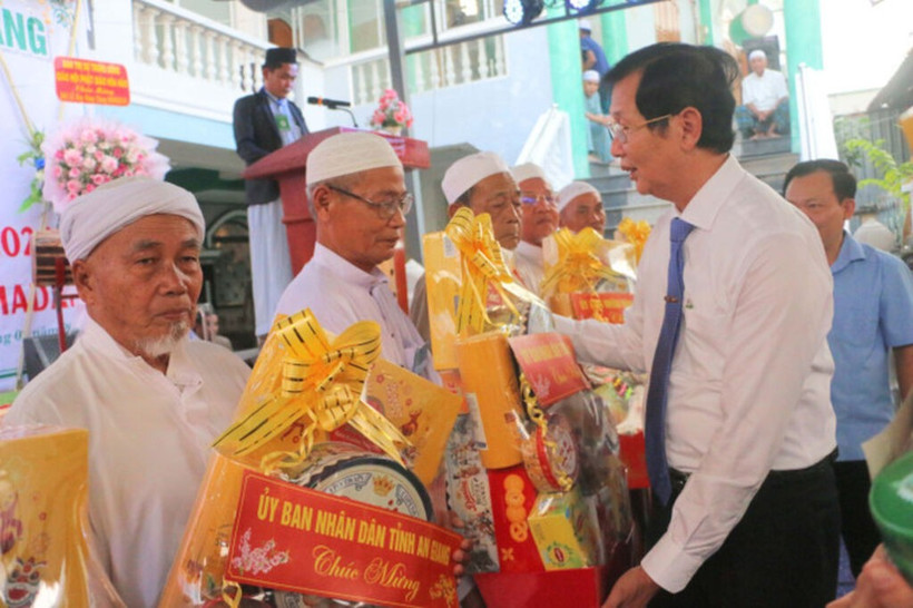 安江省人民委员会副主席黎文福（右）在迎接斋月仪式之际，向安江省伊斯兰清真寺和小清真寺管理委员会代表赠送礼物。