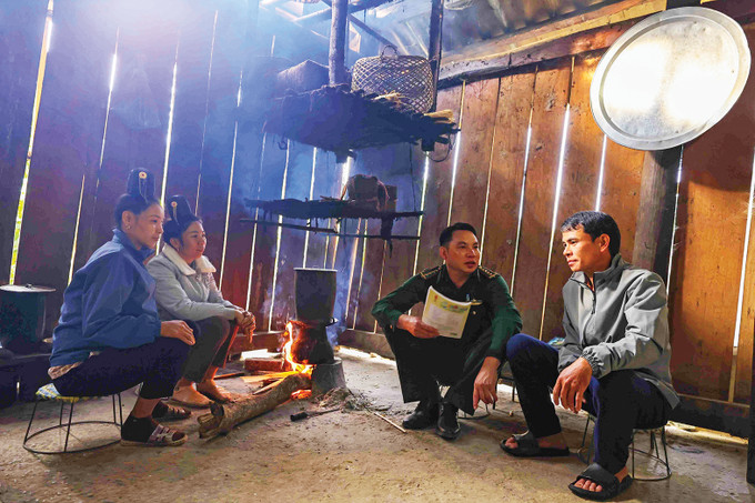 绿色军衔教师卢文话深入山罗省数及边界县芒瓦乡帕光村,挨家挨户动员村民送孩子上学 5-guong sang soi chung.jpg