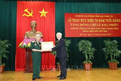 越共中央总书记、国家主席阮富仲向原越共中央总书记黎可漂授予70周年党龄纪念章
