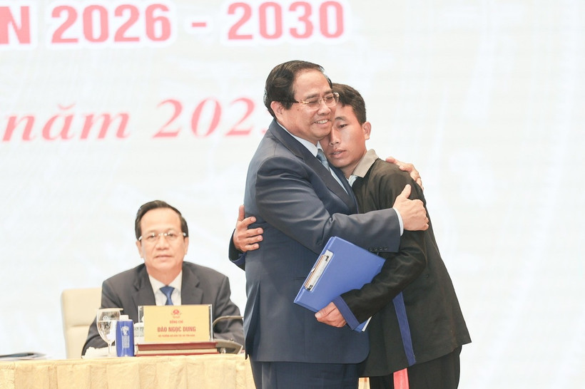 越南政府总理范明政对洪水和山体滑坡灾害中营救奠边省车容乡杭普喜村90 名村民的村长莫阿诗予以鼓励表扬。图自越通社