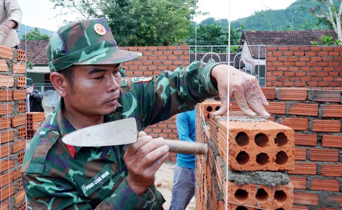 广义省军事指挥部第一地区防御指挥部（山靖）官兵加紧为西茶地区民众施工建房。图自越通社