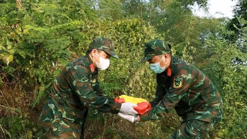 庆和省军事指挥部烈士遗骸搜寻归集队越过森林，将搜寻到的烈士遗骸运回万宁乡烈士纪念碑。图自越通社