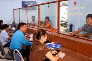 劳寨乡公共行政服务中心工作人员指导群众办理行政手续。图自越通社